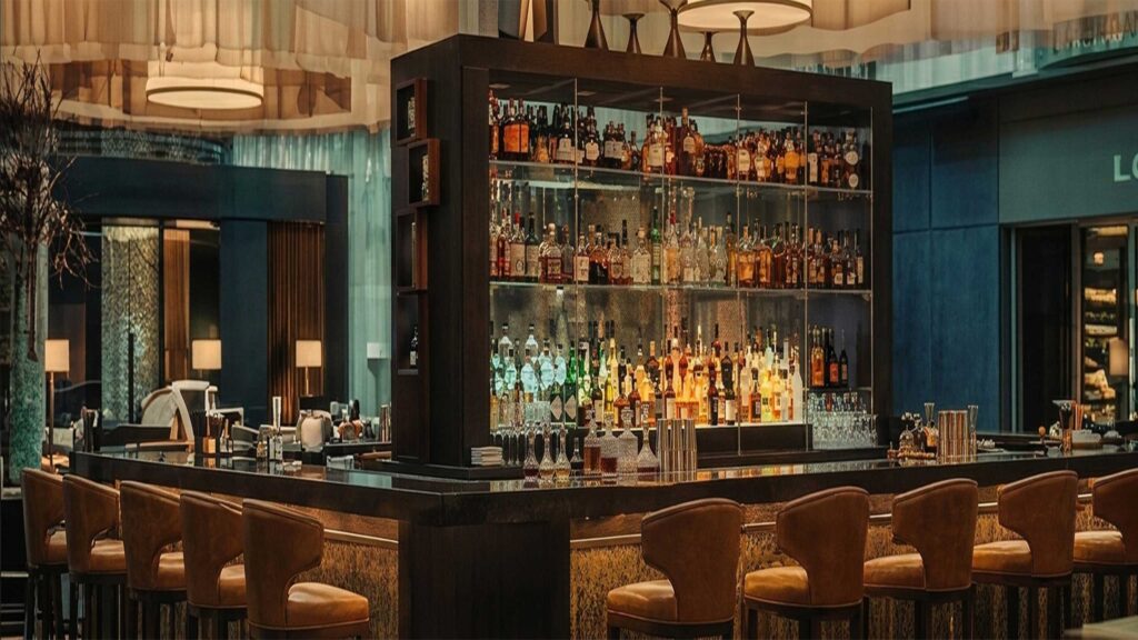 Hospitality Art Projects 10 Sophisticated warm-toned high-end bar and restaurant lounge area featuring curated custom wall art and premium hospitality lighting design.