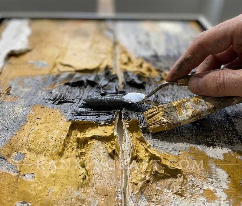 Close-up view of an artist using a palette knife to apply thick oil paint on an impasto canvas
